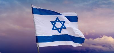 Israeli flag with blue star of David over Jerusalem on cloudy sky sunset background