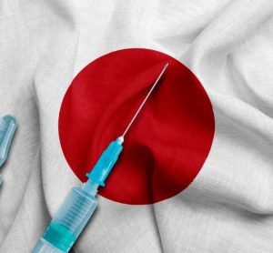 Japanese flag (white wth red central circle) with two syringes labelled 'COVID-19 vaccine' on top