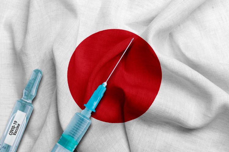 Japanese flag (white wth red central circle) with two syringes labelled 'COVID-19 vaccine' on top