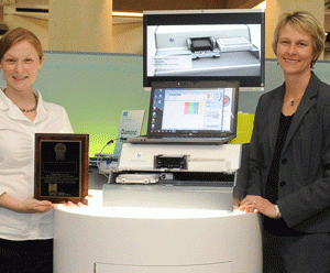 Jessica Merlino, Tecan Product Manager, and Christie Dudenhoefer, HP Instrument Design Lead, accept the award