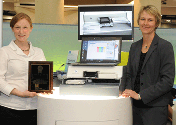 Jessica Merlino, Tecan Product Manager, and Christie Dudenhoefer, HP Instrument Design Lead, accept the award