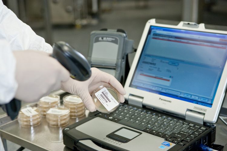 Scientist using scanner to read barcode - MODA-EM™ Paperless Solution [© Lonza, Basel]