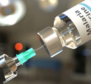Syringe drawing clear liquid from a vial labelled 'MALARIA VACCINE'