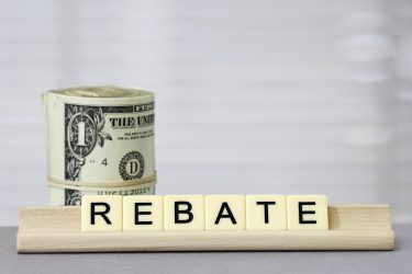roll of dollar bills with the word 'rebate' spelled out in letter tiles in front