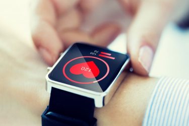 Person wearing smart watch displaying their heart rate and blood pressure - idea of passive, wearable data collection devices