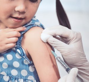 octor injecting vaccination in arm of little girl