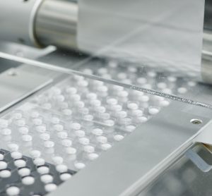 White tablets being sealed into blister packages