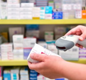 Pharmacist scanning barcode of medicine drug in a pharmacy.