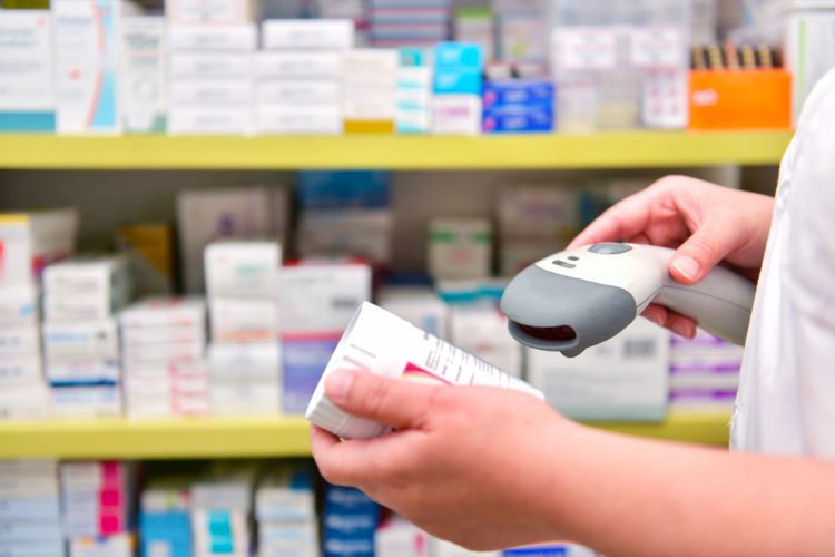 Pharmacist scanning barcode of medicine drug in a pharmacy.