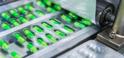 Green medicine capsules on a production line - idea of pharmaceutical manufacturing
