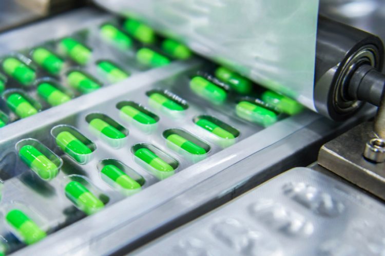 Green medicine capsules on a production line - idea of pharmaceutical manufacturing