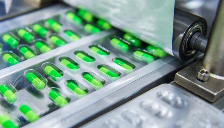 Green medicine capsules on a production line - idea of pharmaceutical manufacturing