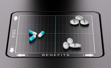 3D illustration of a benefits versus risks matrix with pills and tablets positioned on it