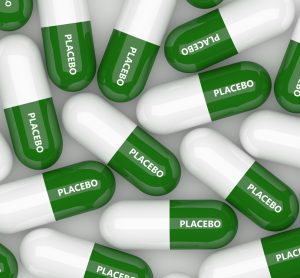 3D illustration of green and white capsules, each labelled placebo