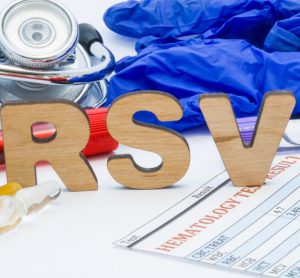 Letters spelling RSV surrounded by various medical equipment and medications - idea of treatment/vaccine development for RSV
