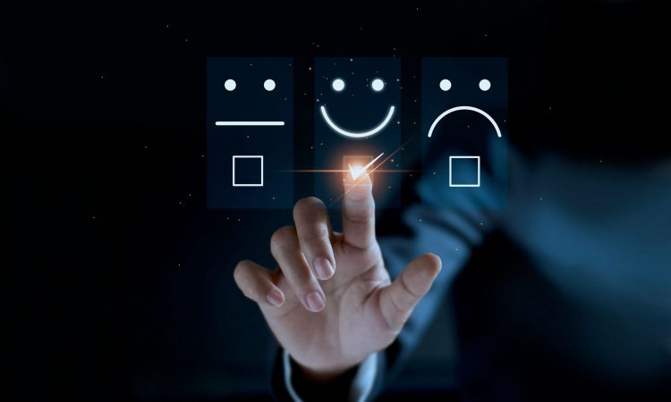 rating system of neutral, smiley and sad face with finger touching the smiled face