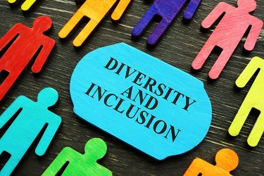 Diversity and inclusion phrase surrounded bu coloured wooden figurines.