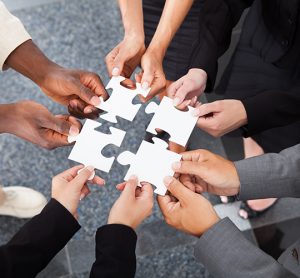 Close-up Photo Of Business people Holding Jigsaw Puzzle Pieces