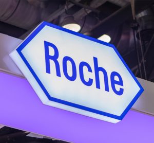 Roche logo sign lit up [Credit: testing/Shutterstock.com].