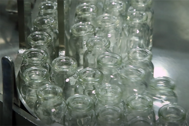 glass medicine vials on a manufacturing line - idea of manufacture of biosimilar drugs