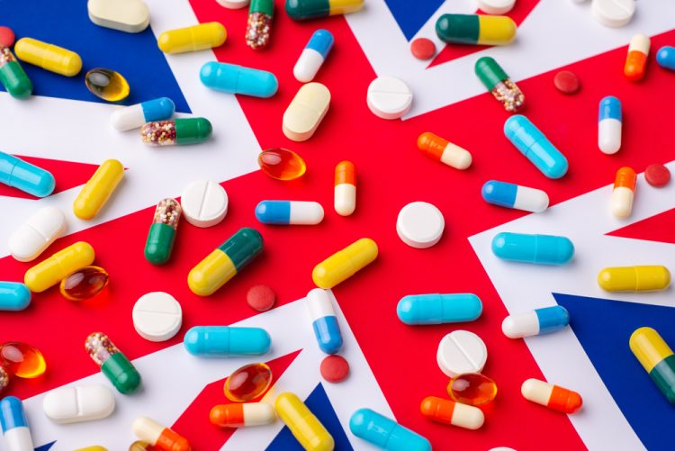 Union Jack visible under various colours, shapes and sizes of pharmaceutical pills and tablets