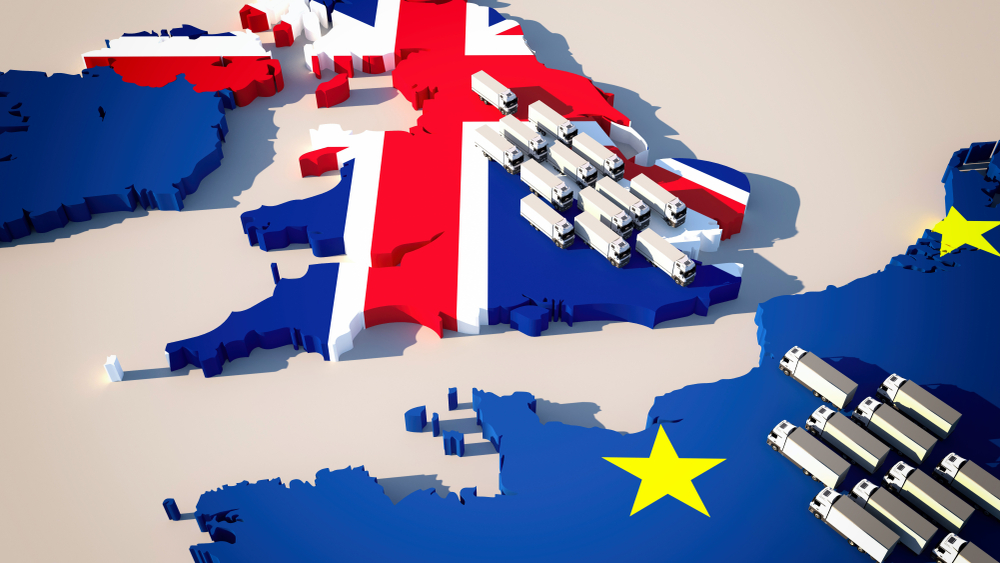 Map with UK in Union Jack colours and Europe in EU flag design with lorries on either site of the British channel - idea of trade between UK and EU/trade deal