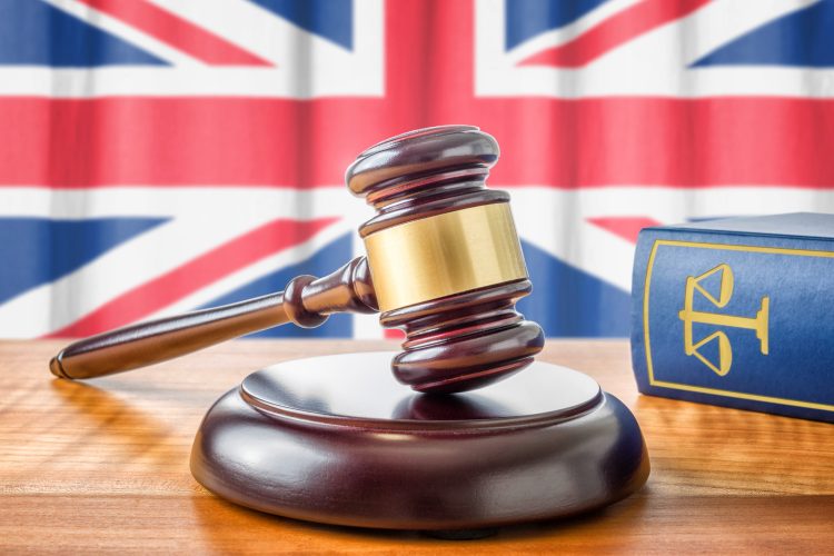 gavel and law book on a table in front of the Union Jack - idea of UK regulations