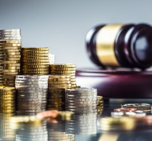 Gavel next to a stack of coins - idea of regulations to do with investment/UK's National Security and Investment Bill