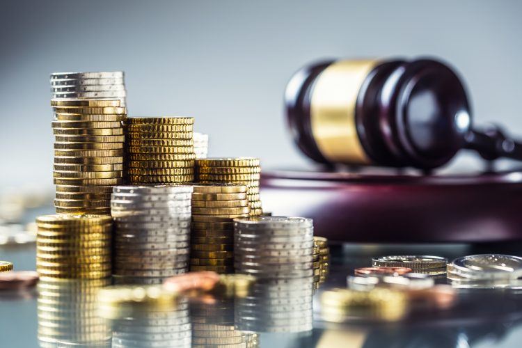 Gavel next to a stack of coins - idea of regulations to do with investment/UK's National Security and Investment Bill