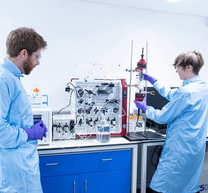 Scientists in personal protective equipment working in a lab