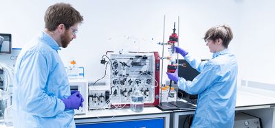 Scientists in personal protective equipment working in a lab