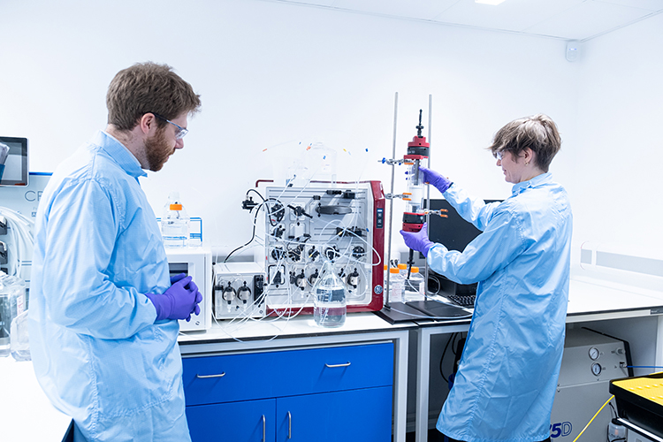 Scientists in personal protective equipment working in a lab