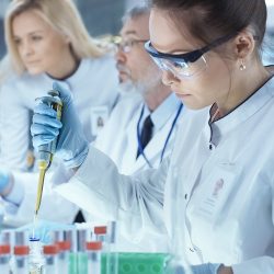 Scientist pipetting liquid into test tubes