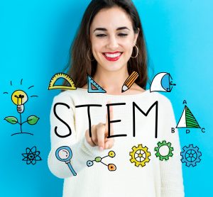 Word 'STEM' surrounded by symbols representing maths, computing and science overlaid on a smiling woman in a white work shirt