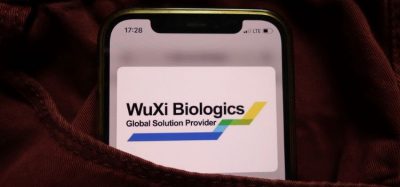 WuXi Biologics logo on a lit up phone screen [Credit: Piotr Swat/Shutterstock.com].