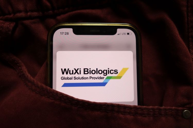 WuXi Biologics logo on a lit up phone screen [Credit: Piotr Swat/Shutterstock.com].