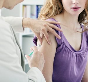 close up of an adolescent girl receiving a vaccine from a doctor in a white coat - idea of COVID-19 vaccines approved in people aged 12 years and over