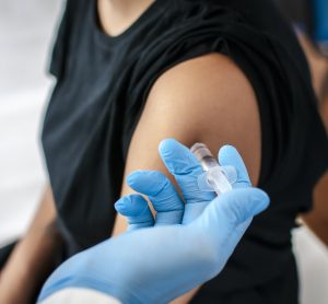 adolescent woman recieving a vaccination in the top of her arm