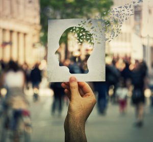 man holding paper with cut out of the brain