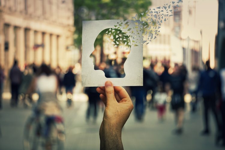 man holding paper with cut out of the brain