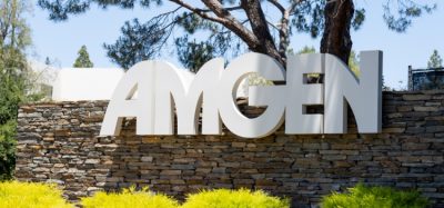 Close up of Amgen sign at its headquarters in Thousand Oaks, California, USA [Credit: JHVEPhoto/Shutterstock.com].