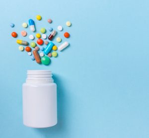 bottle with assorted pills coming out of it