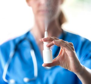 Close-up of female doctor spraying a nasal spray