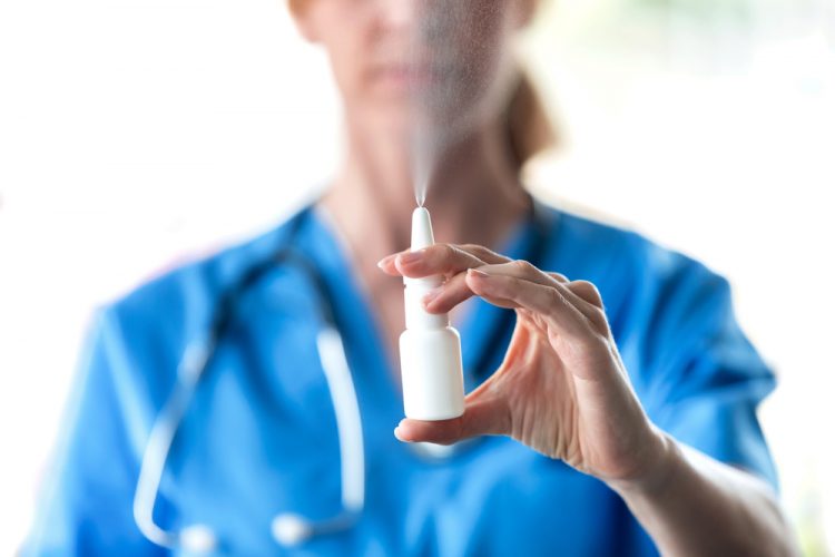 Close-up of female doctor spraying a nasal spray