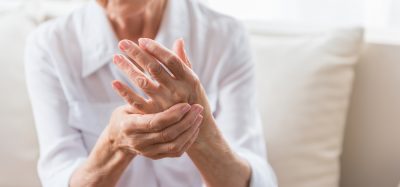 Elderly woman rubbing her hand -idea of joint pain due to arthritis