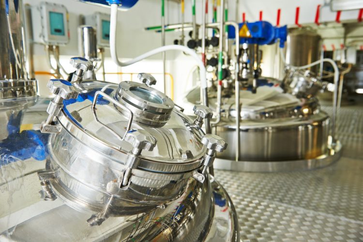 stainless steel bioreactors in a factory - idea of biopharmaceutical production/drug development