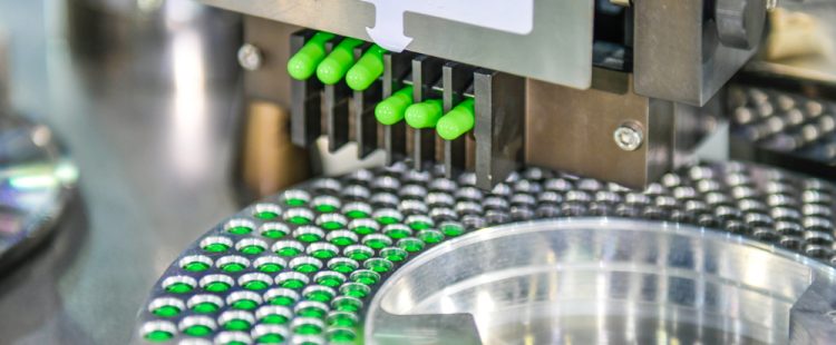 Lime green capsules being released from a machine in a manufacturing line