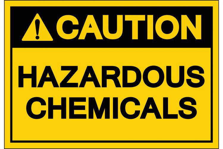 yellow warning label reading 'caution hazardous chemicals' in black