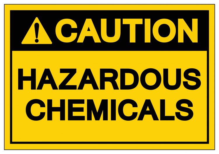 yellow warning label reading 'caution hazardous chemicals' in black