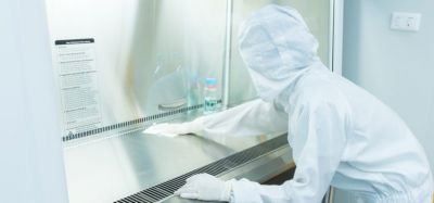 A scientist in sterile coverall gown using alcohol 70% and cleanroom wipes for cleaning Biological safety cabinet(BSC.) in laboratory